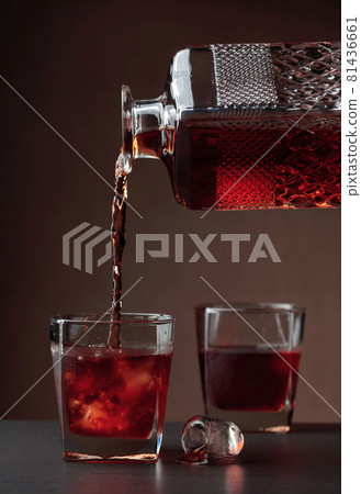 Whiskey pours into a frosted glass with natural ice. 81436661