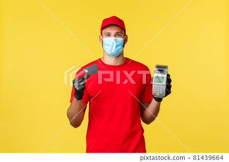 Food delivery, tracking orders, covid-19 and self-quarantine concept. Courier in red uniform, medical mask and gloves, showing POS terminal and credit card, contactless paying during coronavirus Food delivery, tracking orders, covid-19 and self-quarantine concept. Courier in red uniform, medical mask and gloves, showing POS terminal and credit card, contactless paying during coronavirus 81439664