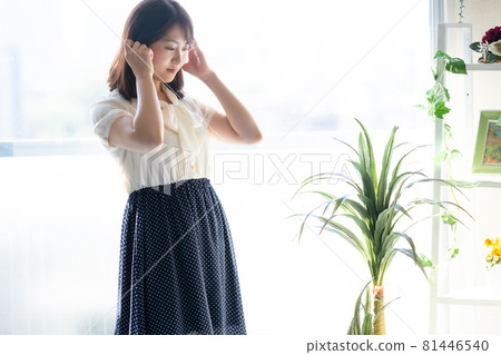 Woman touching her hair in the living room 81446540