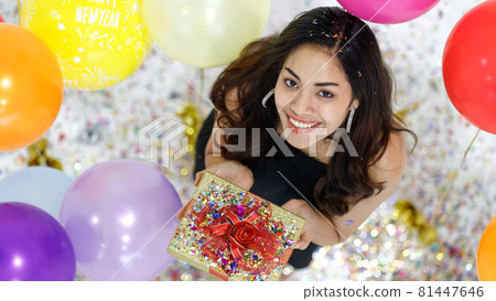 Two young and beautiful sexy Asian girls with colorful gift box dancing and playing with fun and happiness in a party with the bright color balloon in the background. Taken from a top-down angle. Two young and beautiful sexy Asian girls with colorful gift box dancing and playing with fun and happiness in a party with the bright color balloon in the background. Taken from a top-down angle. 81447646