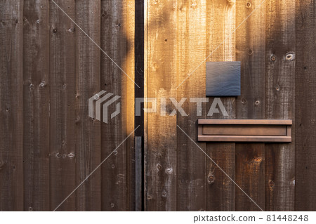 Nameplate and mailbox attached to the board wall of the house 81448248