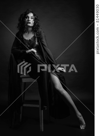 Young beautiful woman with long curly hair in negligee. 81449030