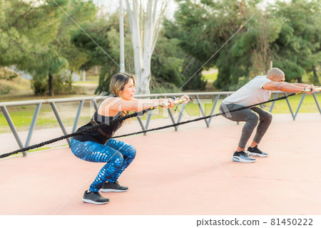 Fitness people exercising with a fitness strap in the park Fitness people exercising with a fitness strap in the park 81450222
