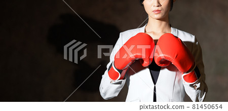 Business woman wearing fighting pose with boxing gloves 81450654
