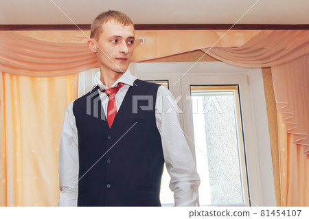 Minsk Belarus Cheerful groom stands in a black tuxedo Minsk Belarus Cheerful groom stands in a black tuxedo 81454107