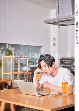 Young man getting drunk at an online drinking party 81457145