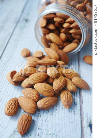 Close up of almond nut spilling from a container Close up of almond nut spilling from a container 81458617