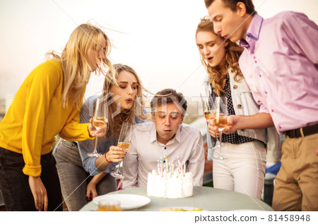 Young happy guy blows candles in his Birthday make a wish 81458948