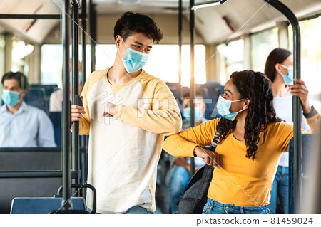 Diverse multicultural people wearing face masks greeting and bumping elbows 81459024