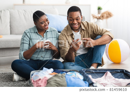Black Tourists Couple Using Smartphone Browsing Internet Near Suitcase Indoor Black Tourists Couple Using Smartphone Browsing Internet Near Suitcase Indoor 81459610