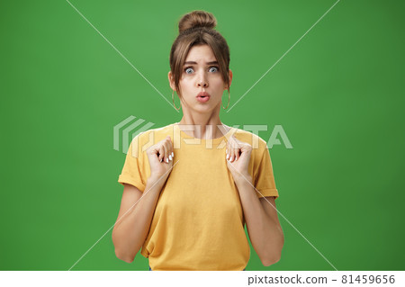 Studio shot of silly insecure and timid young wife feeling troubled and concerned, pressing hands to body folding lips and frowning looking scared and nervous facing troublesome situation, worry Studio shot of silly insecure and timid young wife feeling troubled and concerned, pressing hands to body folding lips and frowning looking scared and nervous facing troublesome situation, worry 81459656