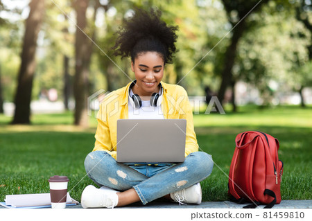 African American College Girl Using Laptop Sitting Learning In Park 81459810