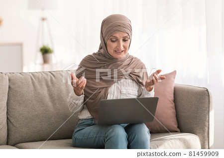 Middle-Eastern Woman Video Calling Using Laptop Sitting On Sofa Indoor Middle-Eastern Woman Video Calling Using Laptop Sitting On Sofa Indoor 81459909