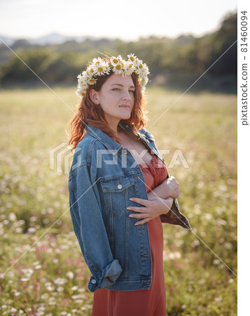 red-haired woman on field on summer evening red-haired woman on field on summer evening 81460094