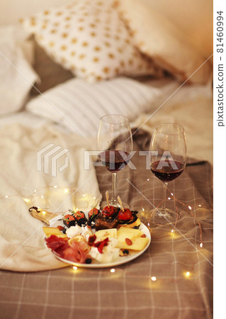 Wine and food on bed 81460994