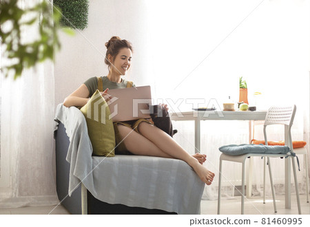 Young female using laptop at home 81460995