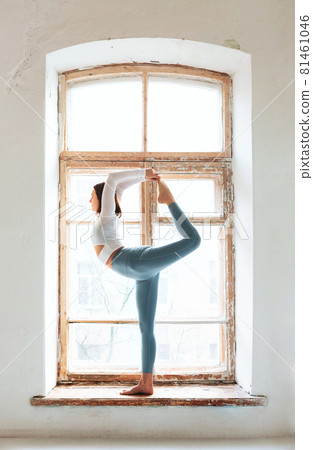 Woman doing yoga near shabby window 81461046
