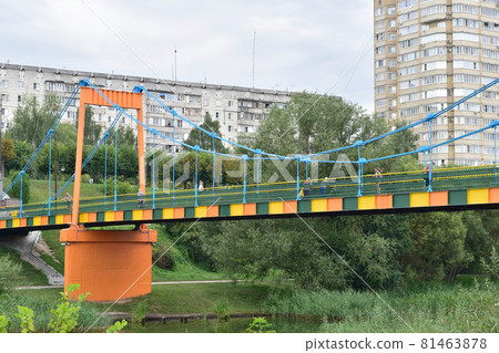 A pedestrian bridge with supports connecting the two banks of the river. 81463878