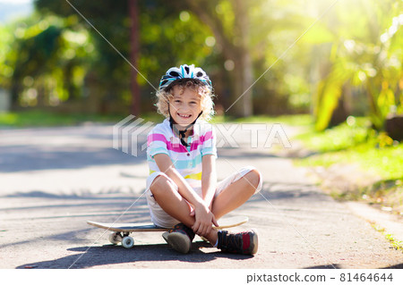 Kid with skateboard. Child riding skate board. 81464644
