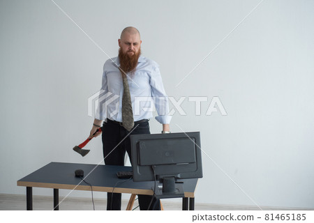 Stressed crazy businessman smashing his computer in office using ax problem concept. The man has problems at work and frustration. 81465185