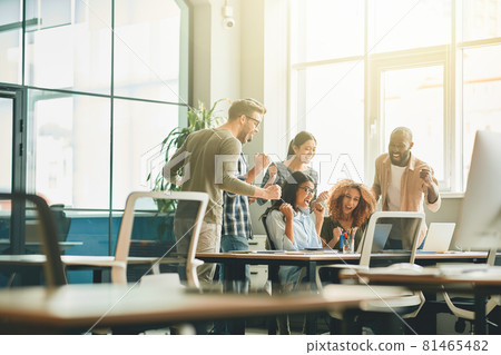 Energetic young people celebrating success of their project at work 81465482