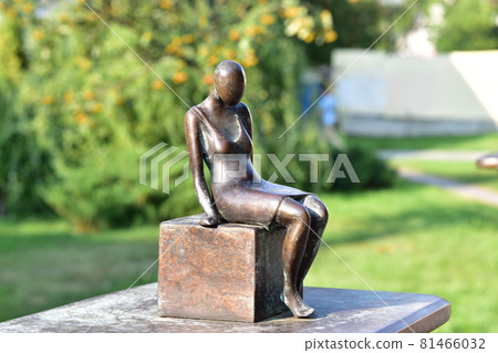 Editorial image. Tambov. Russia. 08.18.2021 The picture shows a bronze statuette of a woman sitting on a cube with her hands down. Editorial image. Tambov. Russia. 08.18.2021 The picture shows a bronze statuette of a woman sitting on a cube with her hands down. 81466032