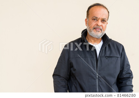 Portrait of handsome bearded Indian man against plain wall Portrait of handsome bearded Indian man against plain wall 81466280