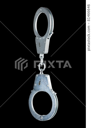 real zinc plated steel police handcuffs closed hanging vertically, isolated on black background real zinc plated steel police handcuffs closed hanging vertically, isolated on black background 81466646