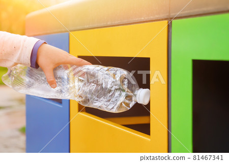 Garbage recycling plastic trash bins. Close up hand throwing plastic bottle recycling container garbage sorting rubbish collection bin. Hand kid put bottle plastic trash can. Reduce waste recycle bins 81467341