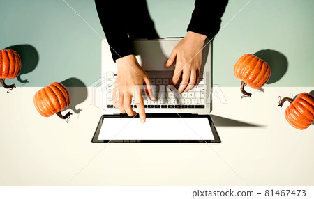 Autumn pumpkins with person using a laptop computer 81467473