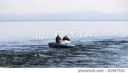 Two men are fishing from boat at the confluence of the river in Lake Baikal. Two men are fishing from boat at the confluence of the river in Lake Baikal. 81467502