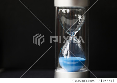 Stylish glass hourglass with blue sand close up Stylish glass hourglass with blue sand close up 81467751