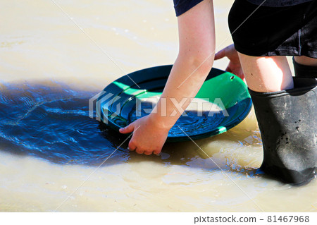 Hands holding a gold pan in the water Hands holding a gold pan in the water 81467968