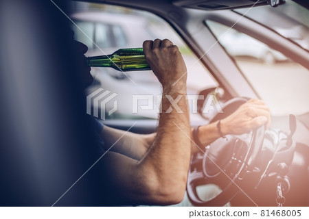 Man drinking beer while driving a car. Man drinking beer while driving a car. 81468005