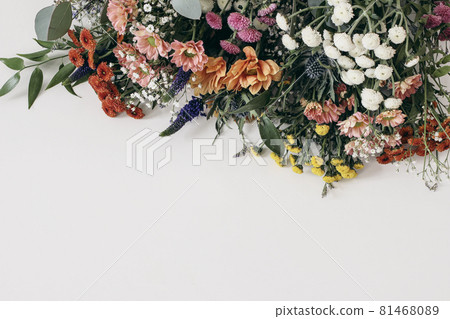 Decorative floral frame, banner. Closeup of Gypsophila and colorful santini mums flowers with eucalyptus isolated on white table background. Empty copy space, top view. Wedding, birthday concept. 81468089