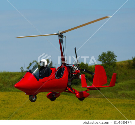 Gyroplane landing over green field Gyroplane landing over green field 81468474