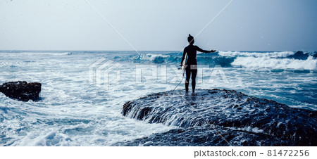 Woman surfer with surfboard going to surf on seaside 81472256