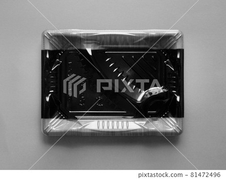 Empty plastic super lunch container placed in the center of gray paper (monochrome) 81472496