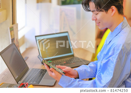 Electrical engineer checking the board with a smile 1 81474250