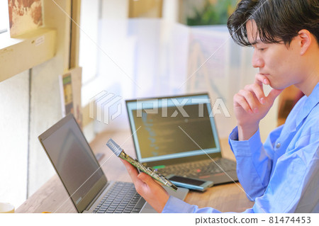 Electrical engineer looking at the board and putting his hand on his chin 1 Electrical engineer looking at the board and putting his hand on his chin 1 81474453