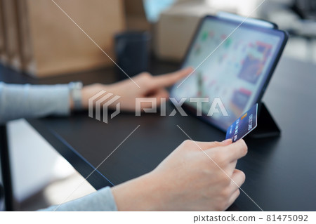 Shopping online concept a young woman using her credit card to facilitate   an online purchasing in online shopping application 81475092