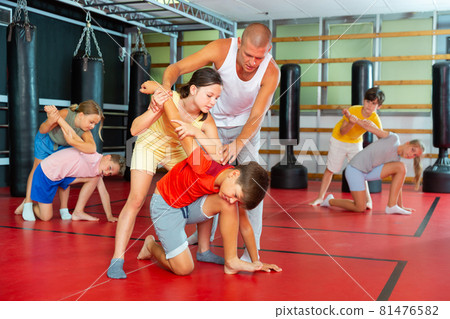 Kids in pair exercising self-defense movements Kids in pair exercising self-defense movements 81476582