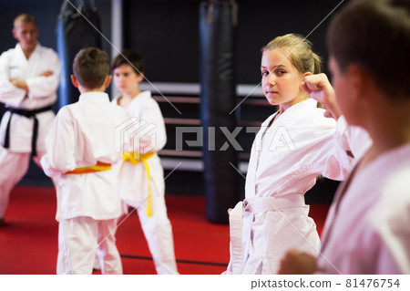 Children sparring in pairs to practice new moves in karate class closeup Children sparring in pairs to practice new moves in karate class closeup 81476754