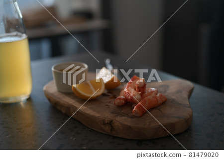 Crab legs with lemon and dressing on olive woob board Crab legs with lemon and dressing on olive woob board 81479020
