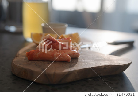 Crab legs with lemon and dressing on olive woob board Crab legs with lemon and dressing on olive woob board 81479031