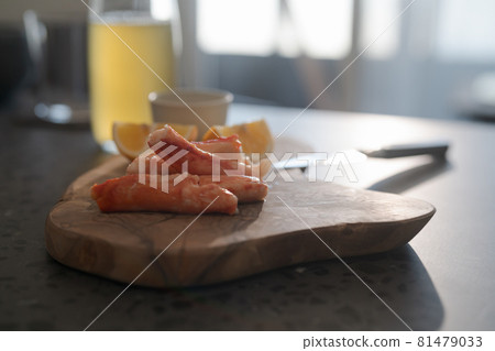 Crab legs with lemon and dressing on olive woob board Crab legs with lemon and dressing on olive woob board 81479033