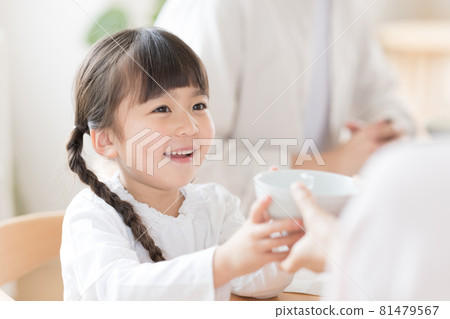 Family meal scene Girl refilling rice 81479567