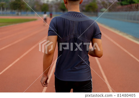 Sports and recreation concept a young male adult running in low speed in the sports stadium as his healthy routine in the evening 81480405