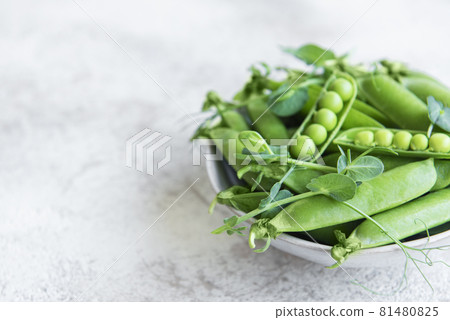 Fresh green peas pods and green peas with sprouts on concrete background. 81480825