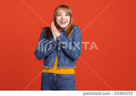 Portrait of young beautiful girl isolated on red studio background. Concept of human emotions, facial expression, youth, sales, ad. 81483255